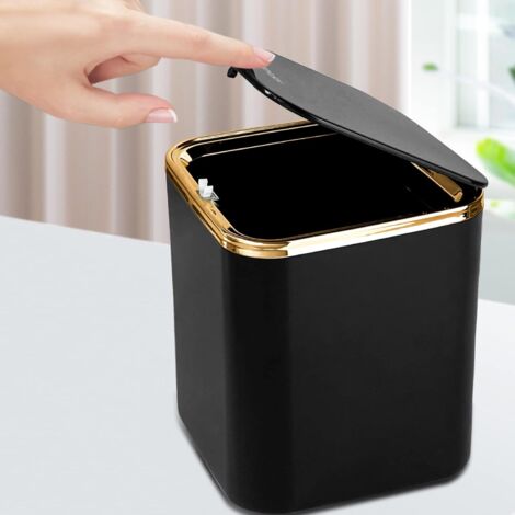 Hand pressing the button lid of a black luxury mini trash can demonstrating easy one-touch open
